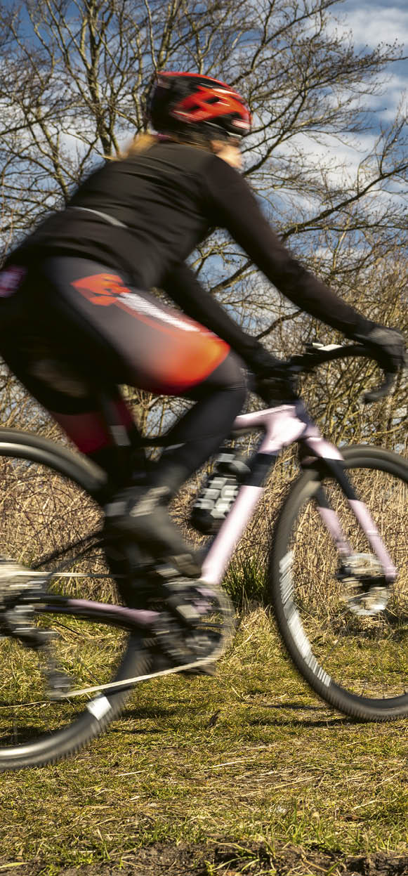 Three people riding bikes on a trail. Description generated by AI