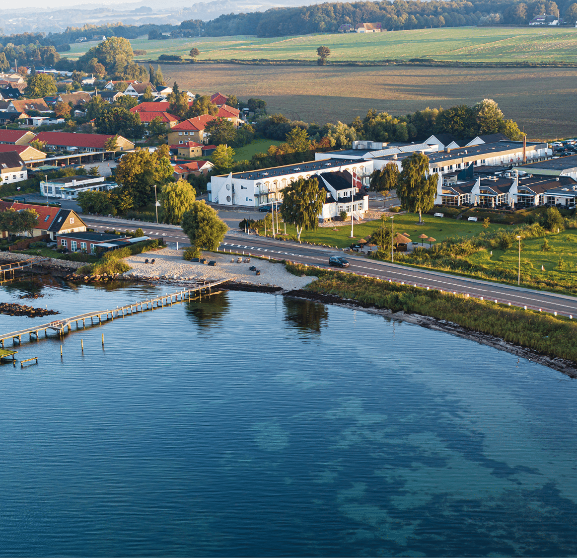 A large body of water with a pier and a town in the background. Description generated by AI